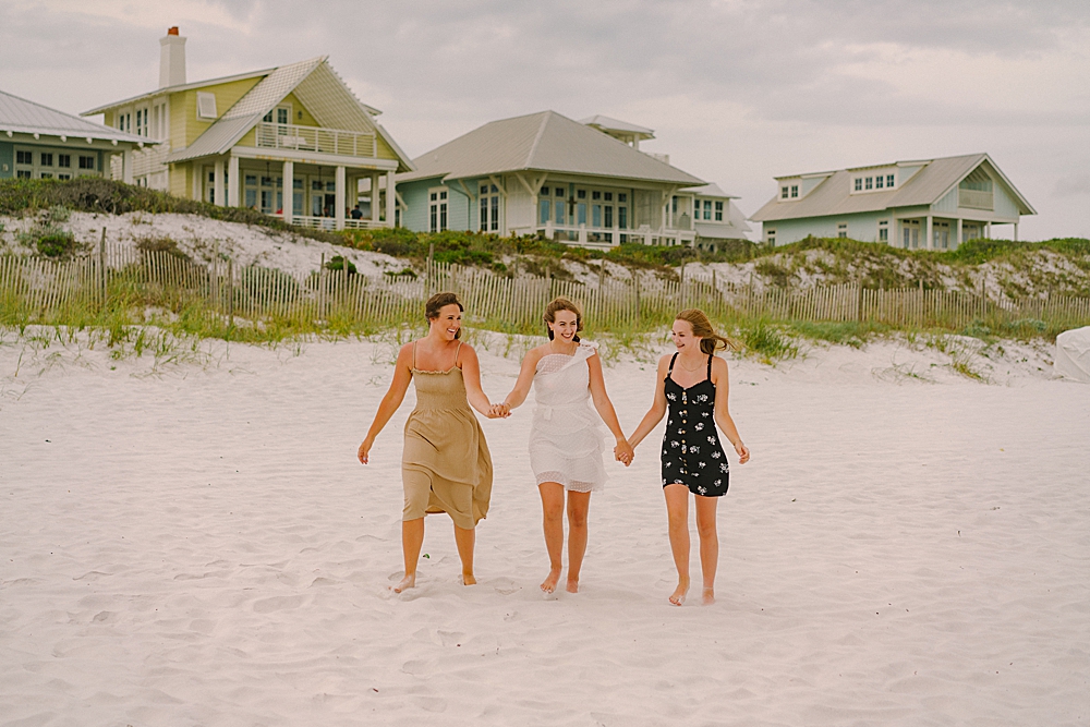 sisters walking in the sand during family photo shoot on 30A
