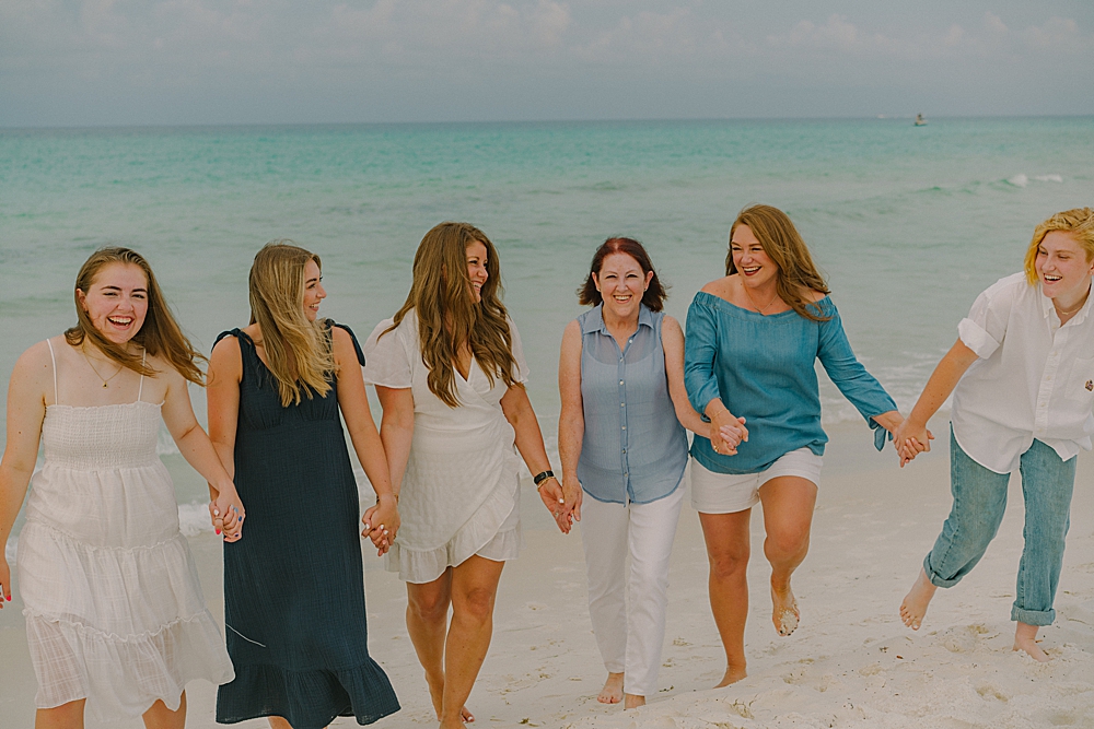 women of the family walking on a beach in 30A during family portraits