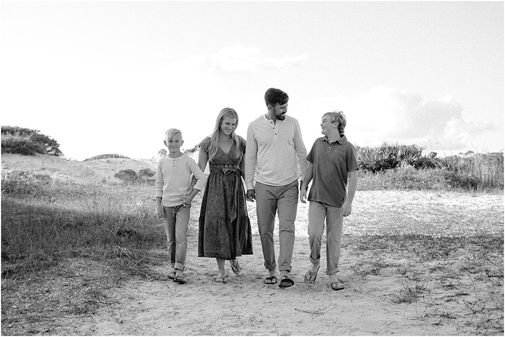 family holding hands and walking on family-friendly beach path in the Destin area